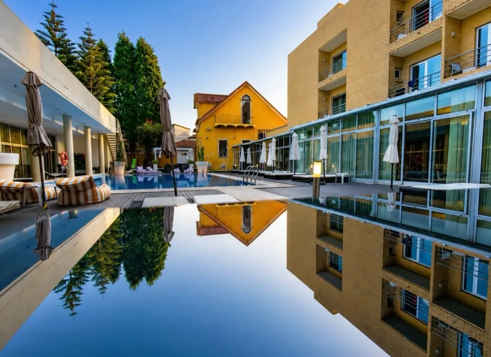 Piscina exterior do Ílhavo Plaza com espreguiçadeiras e palmeiras